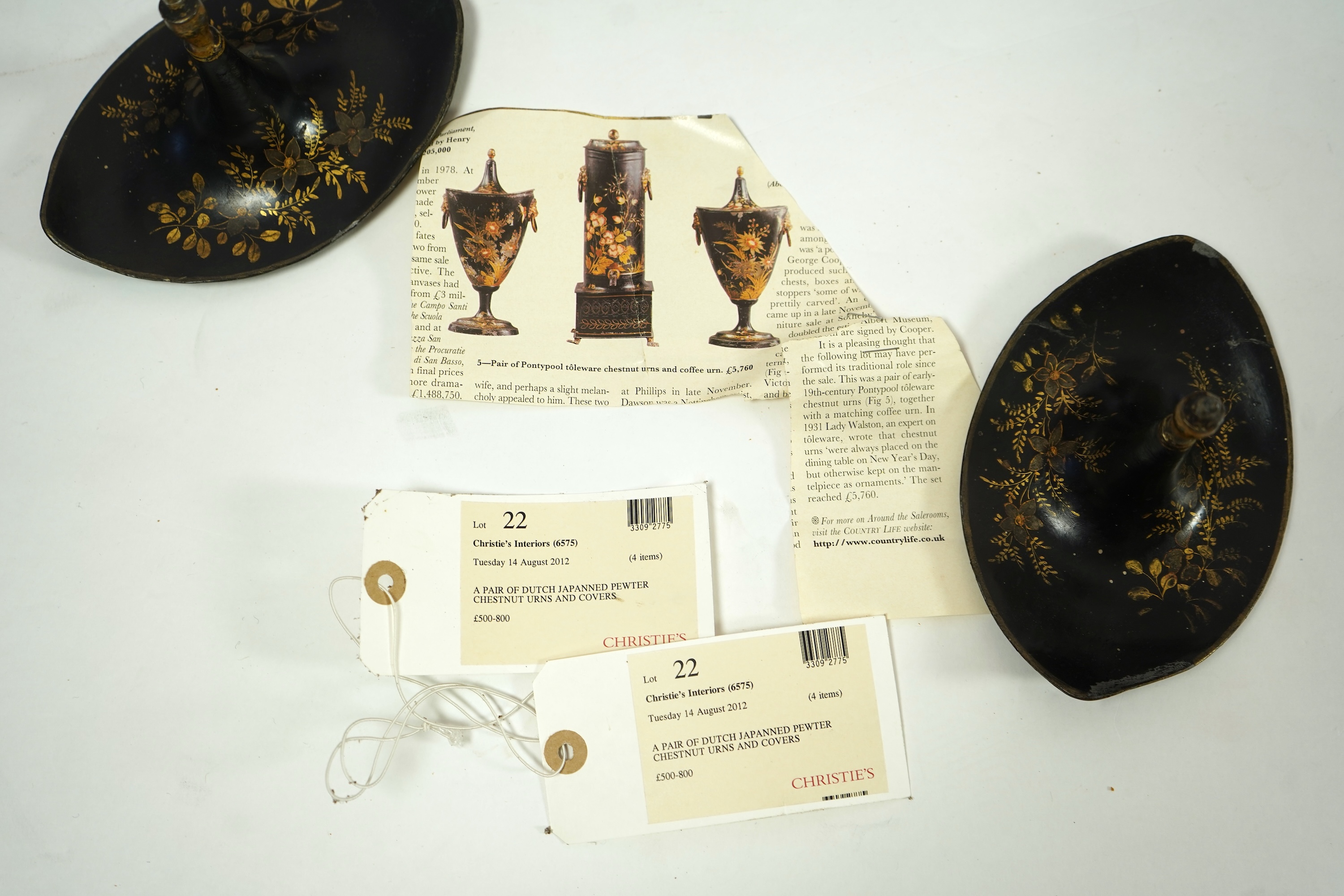 A pair of early 19th century Dutch japanned pewter chest urns and covers, and a tole ware cheese coaster